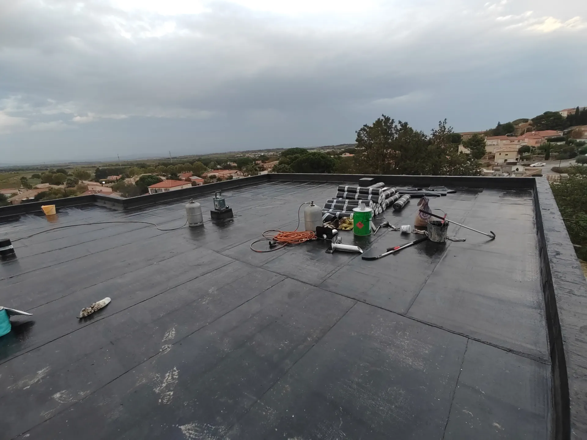 Relevé d'étanchéité sur acrotère avec outils de chantier dans l'Hérault